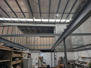 Picture of mezzanine floor during assembly with beams bolted to posts.